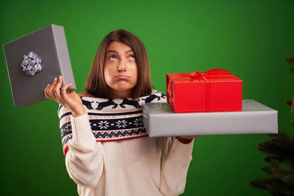 Erwachsene glückliche Frau mit Weihnachtsgeschenk über grünem Hintergrund — Stockfoto