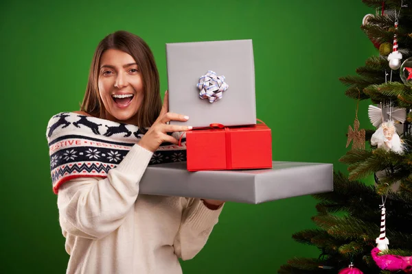 Adult happy woman with Christmas gift over green background — Stock Photo, Image