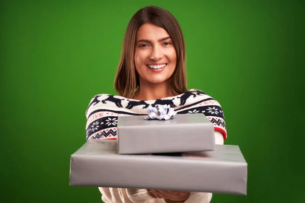 Adult happy woman with Christmas gift over green background — Stock Photo, Image