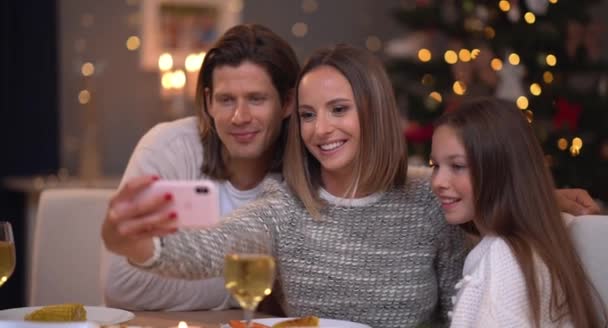 Piękna rodzina obchodzi Boże Narodzenie w domu i biorąc selfie — Wideo stockowe