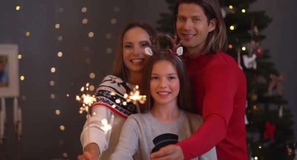 Mooie familie viert Kerstmis en het houden van wonderkaarsen — Stockvideo