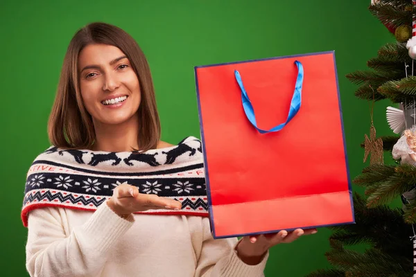 Yeşil arka plan üzerinde Noel hediyeleri için Yetişkin mutlu kadın alışveriş — Stok fotoğraf