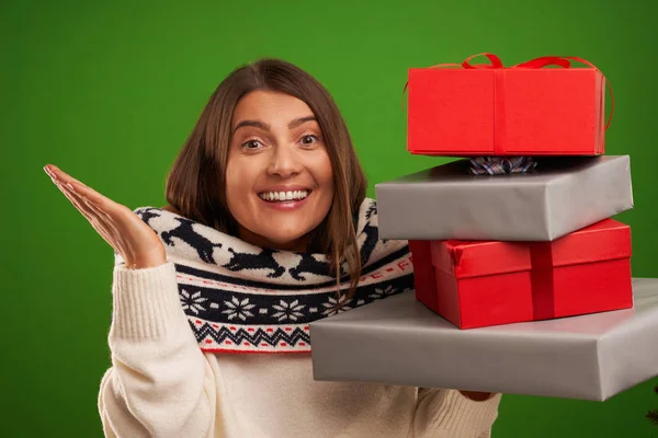 緑の背景の上にクリスマスプレゼントを持つ大人の幸せな女性 — ストック写真