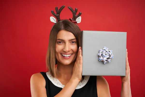 Adulto mulher feliz com presente de Natal sobre fundo vermelho — Fotografia de Stock