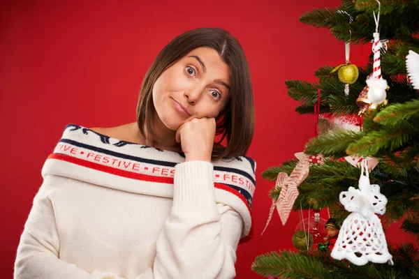Trött kvinna dekorera julgran över röd bakgrund — Stockfoto