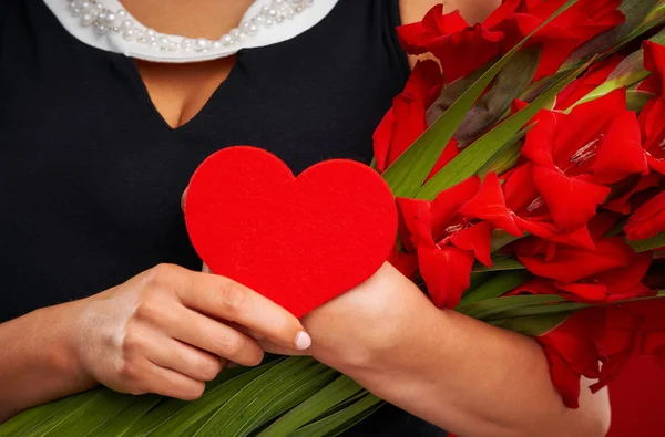 Dorosły kobieta z kwiatami i czerwonym sercem na czerwonym tle — Zdjęcie stockowe