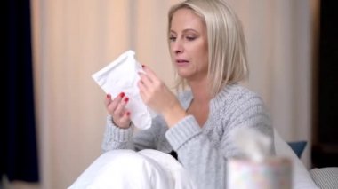 Hasta kadın grip yüzünden yatakta acı çekiyor virüs burnunu mendile sümkürmüş..