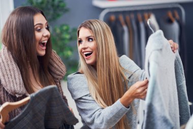 Yetişkin kadınlar sonbaharda butikte kıyafet alışverişi yapıyor.