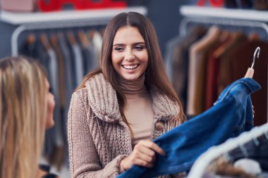 Yetişkin kadınlar sonbaharda butikte kıyafet alışverişi yapıyor.