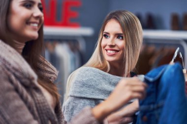Yetişkin kadınlar sonbaharda butikte kıyafet alışverişi yapıyor.