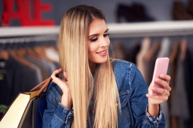 Yetişkin kadınlar sonbaharda butikte kıyafet alışverişi yapıyor.