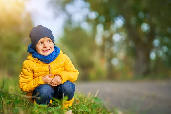 Щасливий хлопчик, який грає на вулиці восени — стокове фото