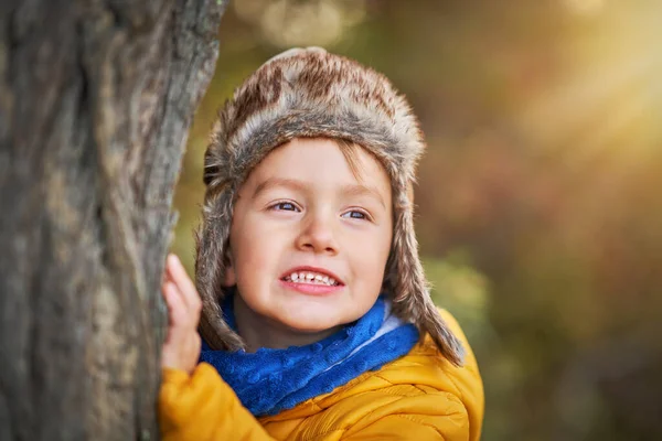 Glücklicher Junge spielt im Herbst draußen — Stockfoto