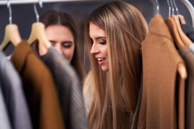Yetişkin kadınlar sonbaharda butikte kıyafet alışverişi yapıyor.