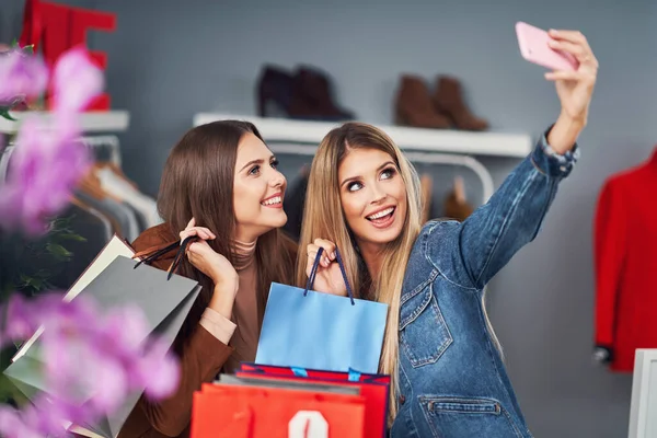 Adult women shopping for clothes in boutique in autumn — ストック写真