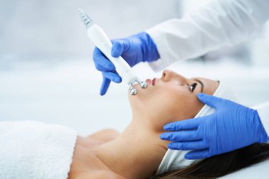 Güzel genç bir kadın güzellik salonunda yüz bakımı yaptırıyor..