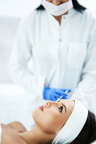 Hermosa mujer joven recibiendo tratamiento facial en el salón de belleza . — Foto de Stock