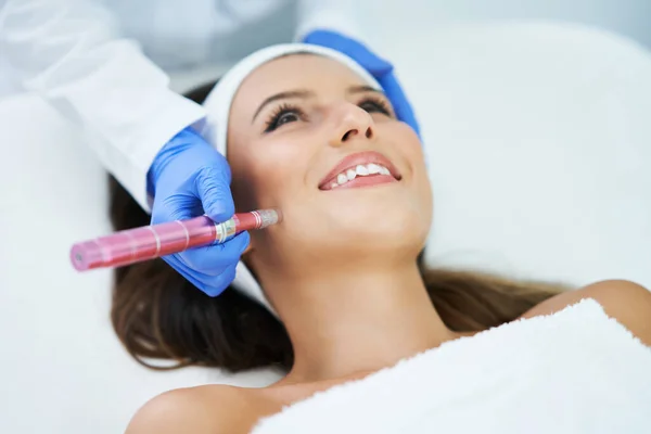 Hermosa mujer joven recibiendo tratamiento facial en el salón de belleza . —  Fotos de Stock