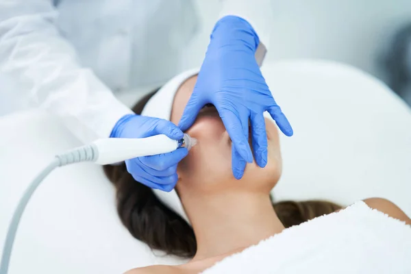 Hermosa mujer joven recibiendo tratamiento facial en el salón de belleza . — Foto de Stock