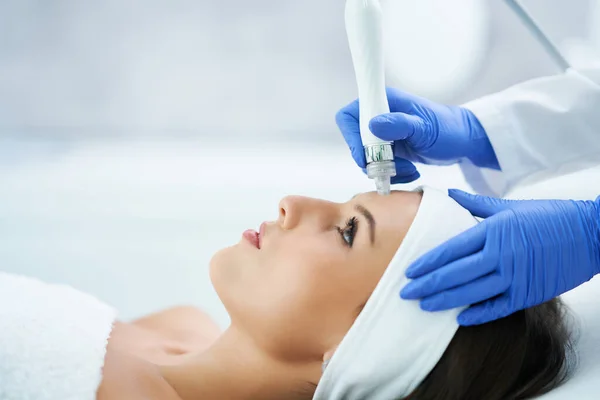 Hermosa mujer joven recibiendo tratamiento facial en el salón de belleza . —  Fotos de Stock