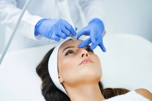 Beautiful young woman getting face treatment at beauty salon. — Stock Photo, Image