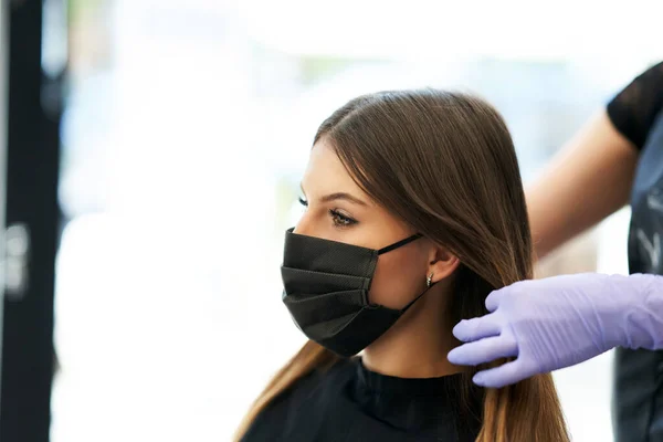 コロナウイルスパンデミックによる保護マスクを身に着けている美容師の大人の女性 — ストック写真