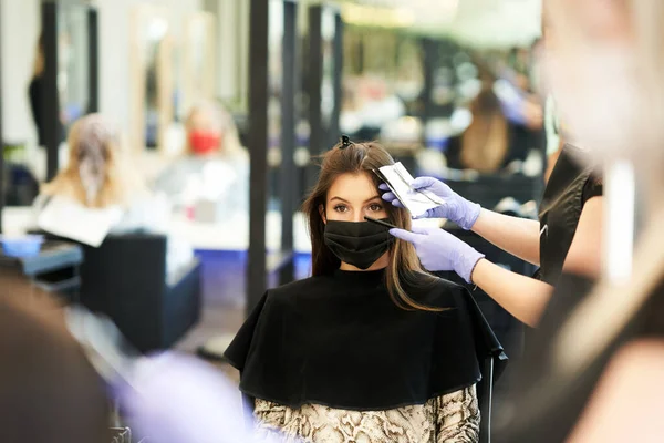 Dorosła kobieta u fryzjera w masce ochronnej z powodu pandemii koronawirusa — Zdjęcie stockowe