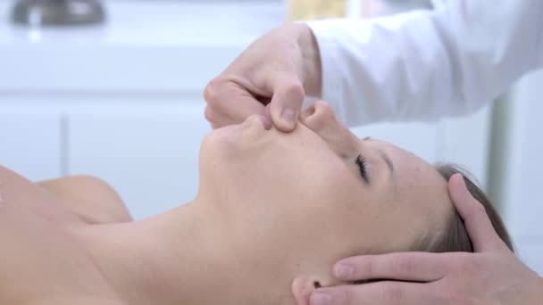 Close-up 4K video de mujer disfrutando de masaje facial japonés en salón profesional — Vídeo de stock