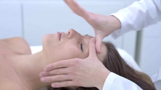 Крупный план 4K видео женщины, наслаждающейся японским массажем лица в профессиональном салоне — стоковое видео