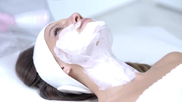 Close-up 4K video van vrouw genietend van gezichtsmasker in professionele salon — Stockvideo