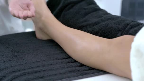 Крупный план 4K видео женщины, наслаждающейся тайским массажем ног в профессиональном салоне — стоковое видео