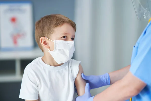 Porträt eines entzückenden kleinen Jungen, der in der Arztpraxis geimpft wird — Stockfoto