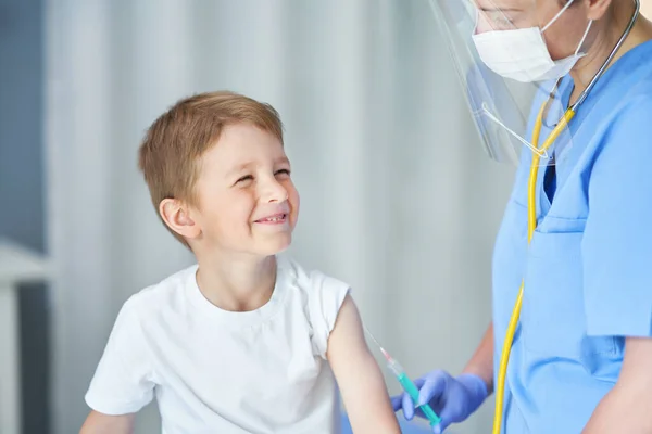 Porträt eines entzückenden kleinen Jungen, der in der Arztpraxis geimpft wird — Stockfoto