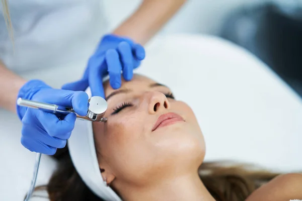 Beautiful young woman getting face treatment at beauty salon. — Stock Photo, Image