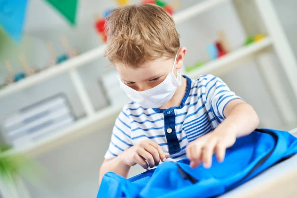 Menino adorável no jardim de infância com máscara devido à pandemia de coronavírus — Fotografia de Stock