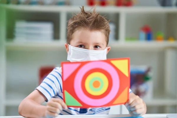 Menino adorável no jardim de infância com máscara devido à pandemia de coronavírus — Fotografia de Stock