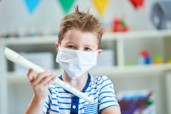 Adorable niño en el jardín de infantes con máscara debido a la pandemia de coronavirus —  Fotos de Stock