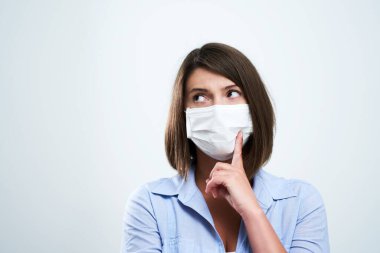 Beyaz arka planda izole edilmiş koruyucu maske takan çekici kadın.