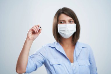 Beyaz arka planda izole edilmiş koruyucu maske takan çekici kadın.