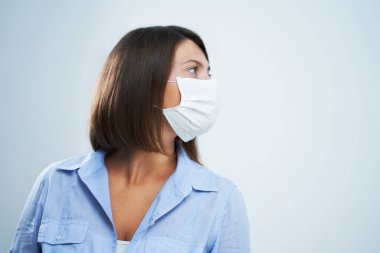Beyaz arka planda izole edilmiş koruyucu maske takan çekici kadın.