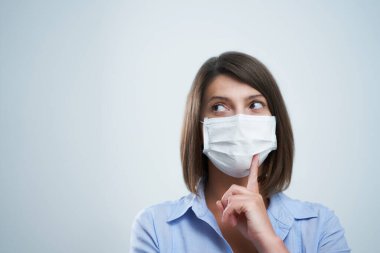 Beyaz arka planda izole edilmiş koruyucu maske takan çekici kadın.