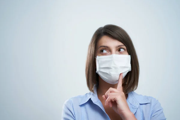 Attraente donna che indossa maschera protettiva isolata su sfondo bianco — Foto Stock