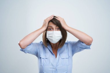 Beyaz arka planda izole edilmiş koruyucu maske takan çekici kadın.