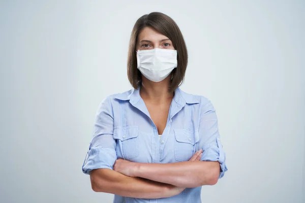 Mulher atraente usando máscara protetora isolada sobre fundo branco — Fotografia de Stock