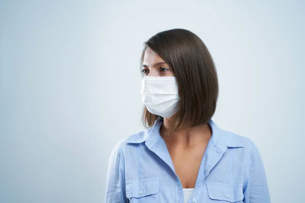Attraente donna che indossa maschera protettiva isolata su sfondo bianco — Foto Stock