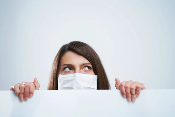 Atraktivní žena nosí ochrannou masku izolované přes bílé pozadí — Stock fotografie