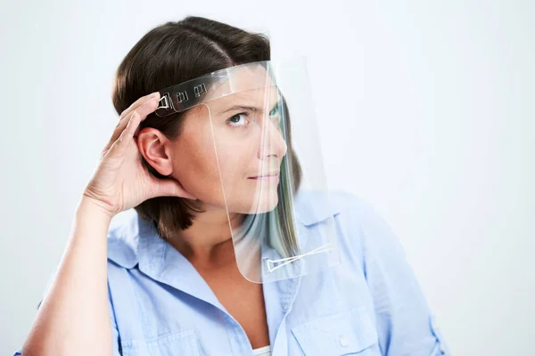 Aantrekkelijke vrouw draagt beschermende schild geïsoleerd over witte achtergrond — Stockfoto