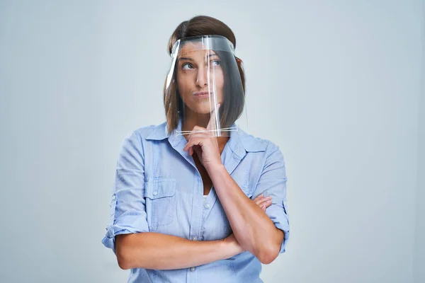 Attraktive Frau mit Schutzschild denkt über weißen Hintergrund nach — Stockfoto