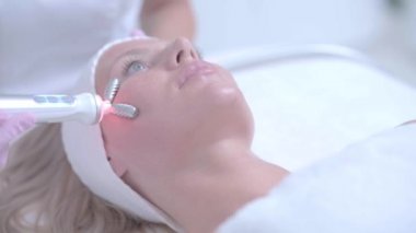 Profesyonel kozmetik uzmanı kadın hidrojen yüz temizliği yapıyor.