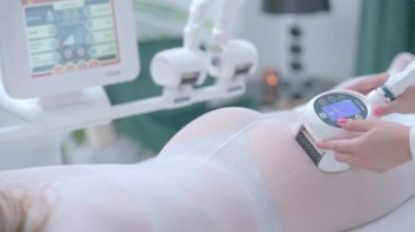 Yetişkin kadın güzellik kliniğinde anti-selülit zayıflatma tedavisi görüyor.